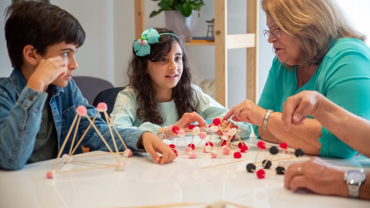 Grandmother playing educational games with grandchildren indoors, fostering creativity and learning.